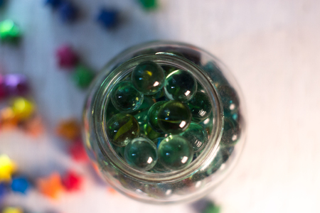Glass balls in a glass jar with a blurred backgroundの写真素材