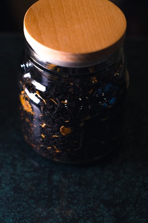 Different types of tea in glass jars on a blurred backgroundの写真素材