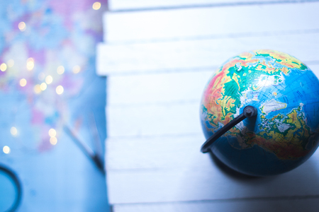 Globe on a wooden white background with a blurred backgroundの写真素材
