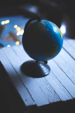 Globe on a wooden white background with a blurred backgroundの写真素材