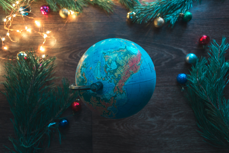 Globe on a wooden background with Christmas decorationsの写真素材