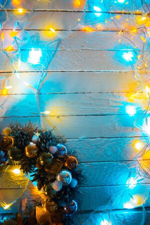 Christmas decorations on a white wooden background with garlandsの写真素材