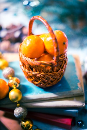 Mandarins in a small basket on a pile of booksの写真素材