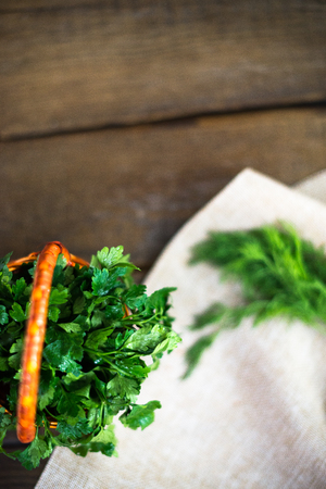 Parsley in a basket on a wooden backgroundの写真素材