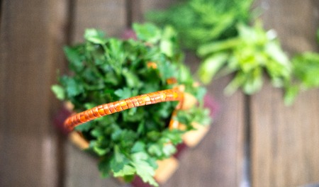 Parsley in a basket on a wooden backgroundの写真素材