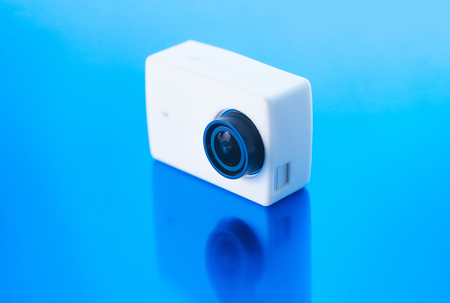 Action camera on a blue glossy background