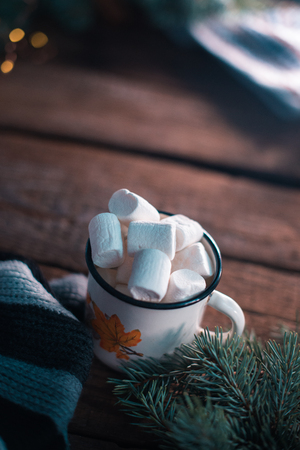 White cup with marshmallow on a wooden backgroundの写真素材