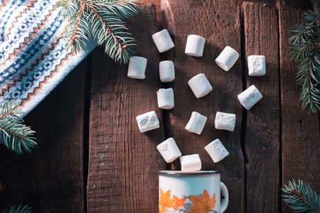 White cup with marshmallow on a wooden backgroundの写真素材