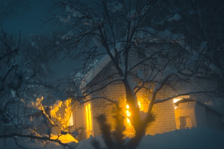 Winter foggy evening in a snow-capped village