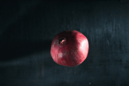 Fresh pomegranate on a black blurred backgroundの写真素材