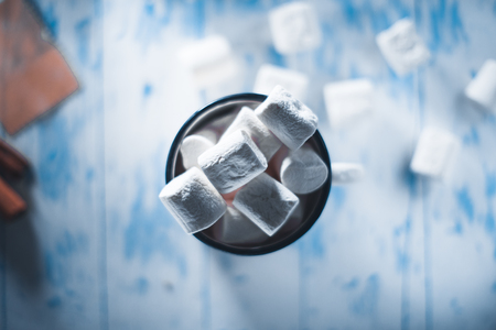 Marshmallow in a cup on a white wooden backgroundの写真素材