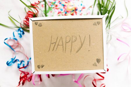 Frame with the inscription Happy on a white background with confetti.
