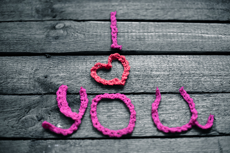 Inscription in knitted letters on a wooden background. Valentine's Day.の写真素材