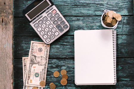 Calculator with money and pennies on a wooden green background. Business concept.の写真素材