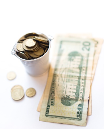 A bucket with pennies dollars on a white background