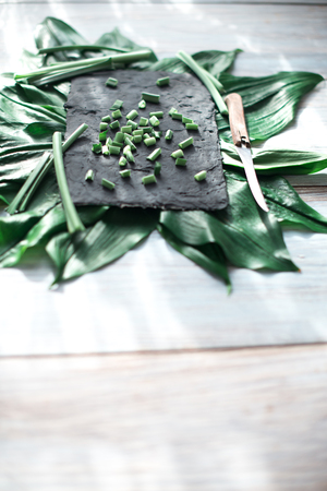 Sliced green stems on a black kitchen board.