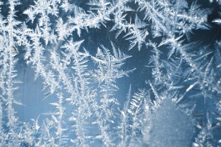 Frosty patterns on the frozen window are macro. Winter background.