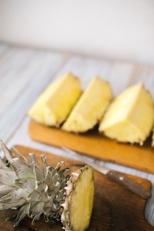 Sliced fresh pineapple on a wooden background in sunlight.の写真素材