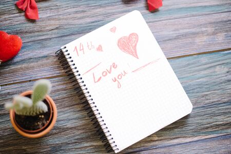 Inscription I love you on a white notepad on a wooden background.の写真素材