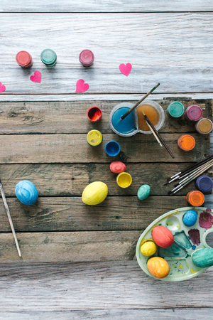 Easter eggs on a wooden background with paints.の写真素材