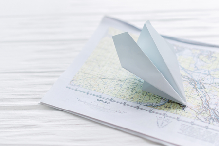 Paper airplane, on a map on a wooden background.の写真素材