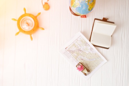 Traveler accessories still life on a white wooden background.