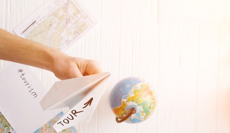 A man is holding a paper airplane in his hand. Still life of a travelerの写真素材