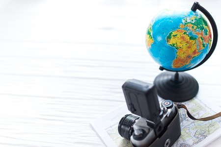 A camera with a globe on a white wooden background. Traveler's Kit.の写真素材