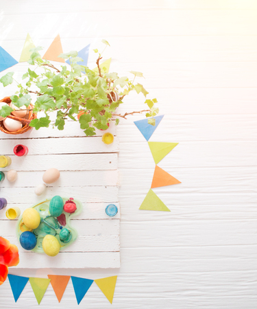 The process of painting Easter eggs still life on a white wooden background.の写真素材