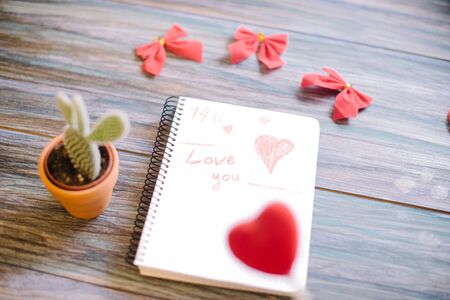Inscription I love you on a white notepad on a wooden background.の写真素材