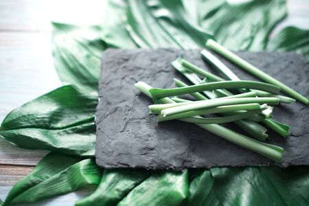 Sliced green stems on a black kitchen board.の写真素材