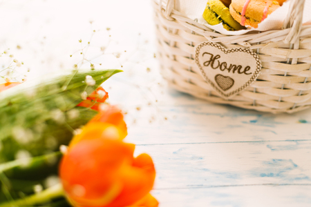 Blossoming tulips near a basket with macaroons.の写真素材