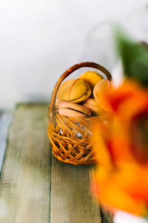 Blossoming tulips near a basket with macaroons.の写真素材