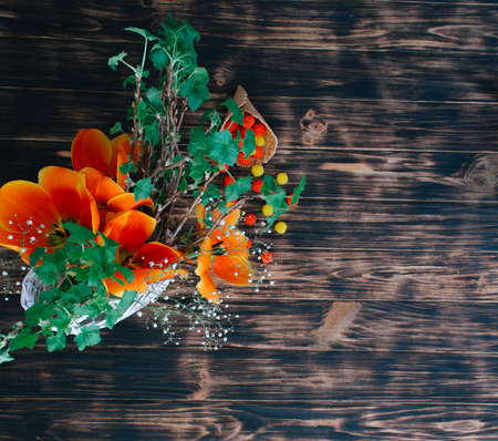 Tulips with sweets in a waffle horn on a wooden background.の写真素材