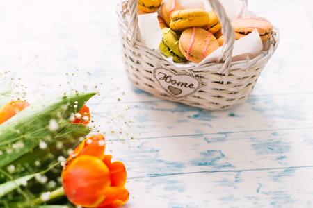 Blossoming tulips near a basket with macaroons.の写真素材