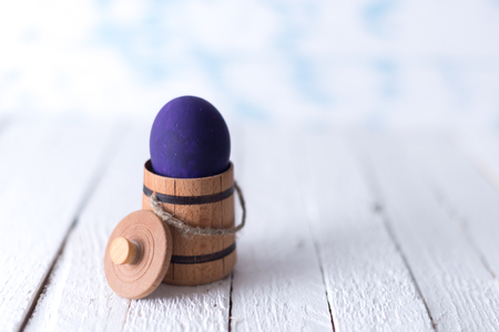 Easter eggs in a small wooden barrel on a blurred background.の写真素材