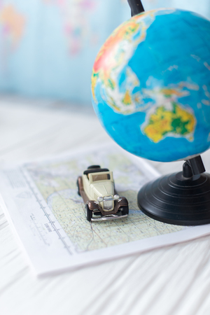 Globe on a wooden white background. The concept of travel.