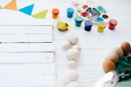 The process of painting Easter eggs still life on a white wooden background.の写真素材