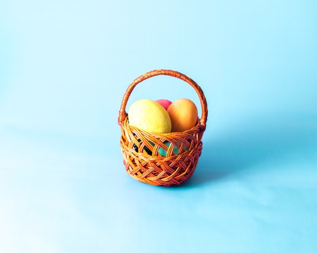Easter eggs in a basket on a wooden background.の写真素材