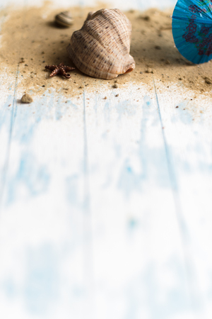 Beach summer background. Umbrellas on a pacifier on a wooden background with a shell.の写真素材
