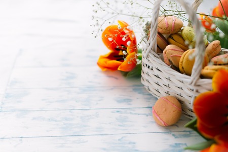 Blossoming tulips near a basket with macaroons.の写真素材
