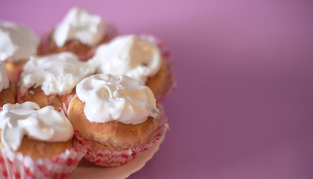 Pink cupcake decorated on a blurred background.
