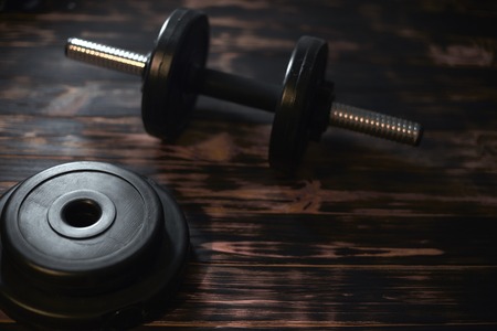Dumbbells on a dark wooden background. Concept CrossFit.