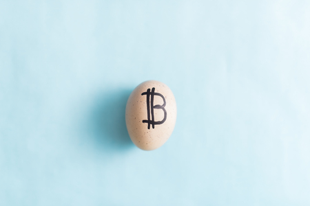 Egg with bitcoin on a blue background.の写真素材