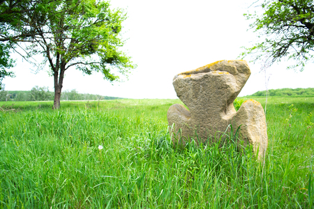 Old stone cross on a green meadow.の写真素材