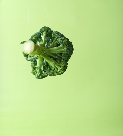 Broccoli in the air on a green background.の写真素材
