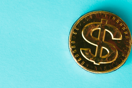 Gold dollar on a blue background. Concept of currencies.の写真素材