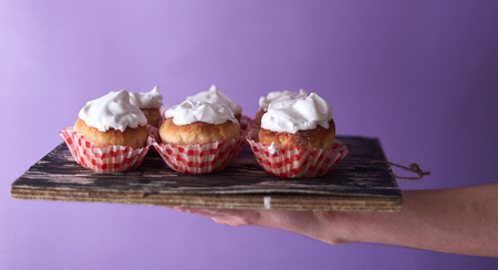 Pink cupcake decorated on a blurred background.