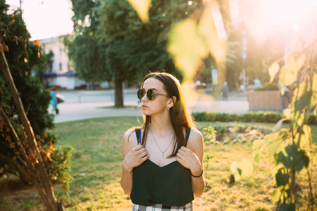Beautiful young girl in a park in sunglasses.の写真素材