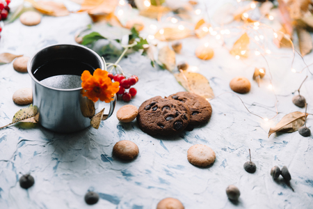 Cup with tea near the window with autumn leaves and cookies.の写真素材